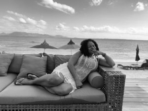 A black and white photo of a woman sitting on a couch.