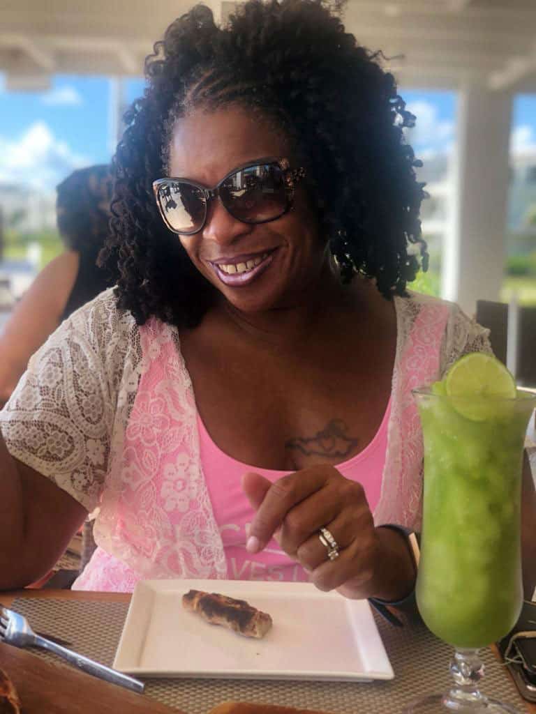 A woman holding a plate of food and a drink.