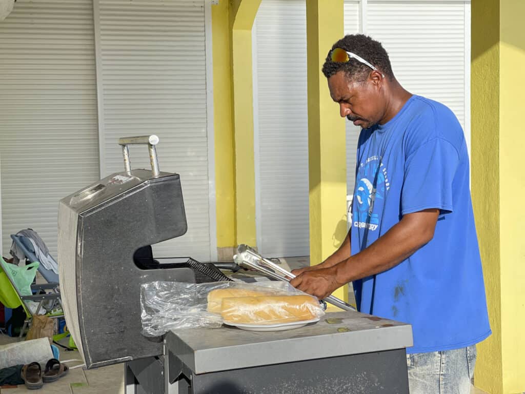 A man is putting bread on a grill.
