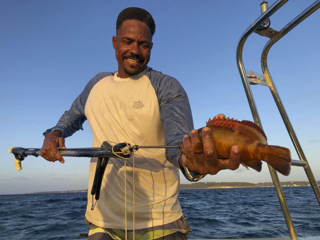 A man holding a fish on a boat.