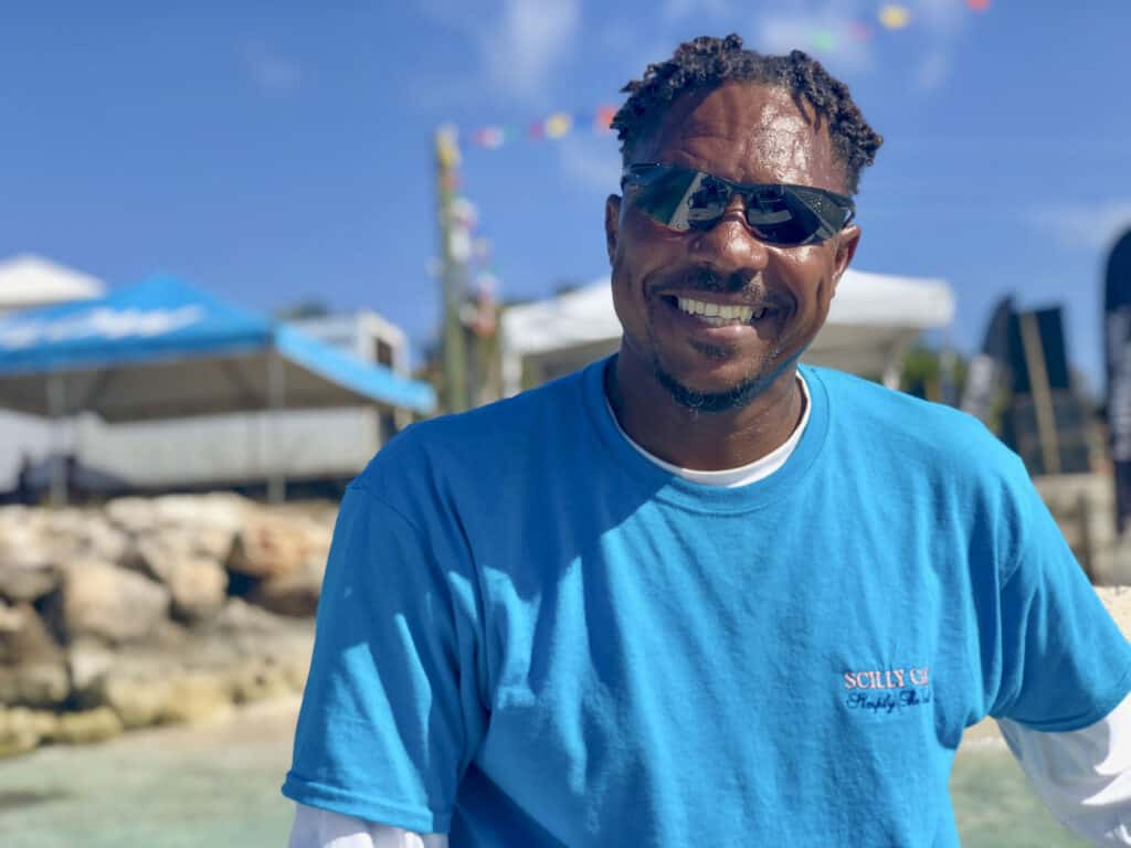 A man in a blue shirt smiling at the camera.