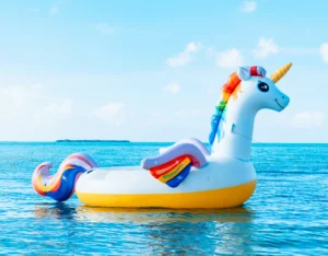 A unicorn shaped inflatable float floating in the ocean.